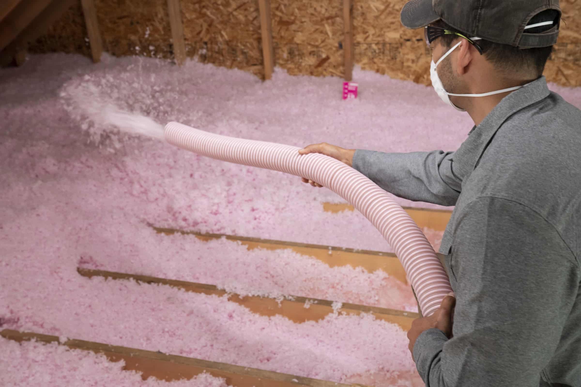 Blowing Loosefill Insulation With A Hose In Attic